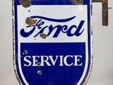 an old blue and white ford service sign sitting on top of a table