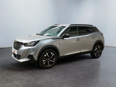 un SUV argenté garé dans une grande pièce au sol noir