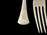 three forks and a knife are shown against a black background