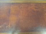 a wooden table with a brown top on a wooden floor