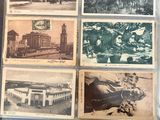 an old photo of a bunch of old postcards sitting on top of a table