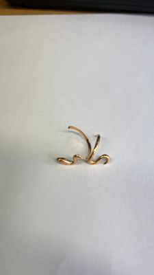 un petit morceau d'or sur une surface blanche