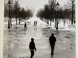 photographie en noir et blanc montrant des personnes marchant dans une rue enneigée