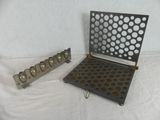 two pieces of metal with holes on them on a white surface