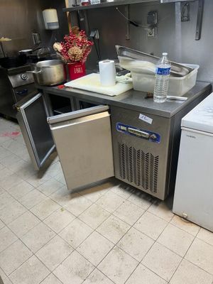 une petite cuisine équipée d'un réfrigérateur et d'un lave-vaisselle