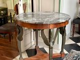 une table au plateau en marbre, placée au milieu d'une pièce