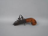 a toy gun with a wooden handle on a white surface