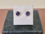 une paire de boucles d'oreilles en saphir bleu posées sur un bloc de marbre