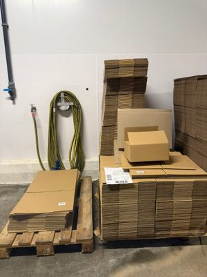 de nombreux cartons empilés sur des palettes dans un entrepôt
