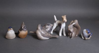 Plusieurs figurines représentant des animaux et des oiseaux sont posées sur une table