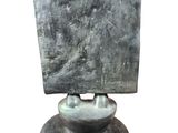 statue of a man holding a square object on top of his head