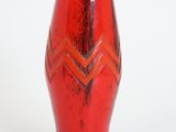 un vase rouge orné d'un motif en chevrons