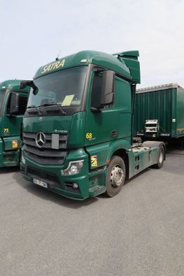 deux camions verts garés l'un à côté de l'autre sur un parking