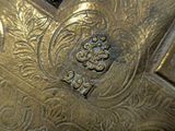 close up of a gold plate with a decorative design on it