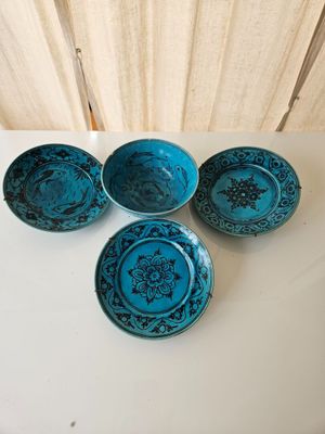 four small blue bowls with designs on them on a table