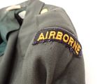 a green jacket with an airborns patch on it