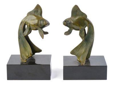 une paire de sculptures de poissons en bronze posées sur des socles en marbre noir