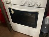 une cuisinière surmontée d'un micro-ondes, dans une cuisine