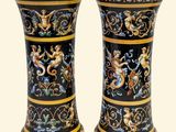 two vases that have been decorated with gold and black designs