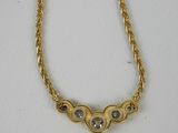 a gold necklace with three hearts on a chain