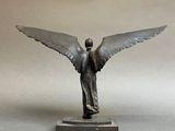 statue of an angel on a marble base against a gray background