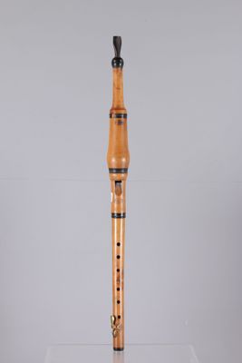 a close up of a wooden flute on a clear surface