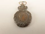 an old silver medal with a crown on top of it