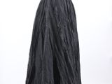 a black dress on a mannequin stand in front of a white background