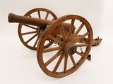 un vieux canon en bois posé sur une roue en bois