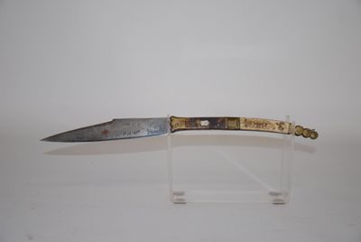 a knife that is on display on a clear stand