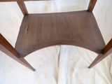 a wooden chair that is sitting on a white sheet