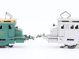 two toy trains sitting side by side on a white surface