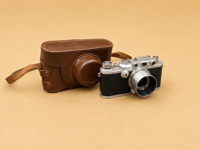 un petit appareil photo et un étui en cuir posés sur une table