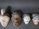 four african masks are lined up against a black background