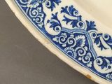 an antique blue and white plate with a floral design on it