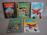 several children ' s books are lined up on a white surface