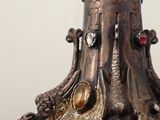 a close up of a vase with a bird on top of it