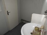 a white sink in the corner of a small bathroom