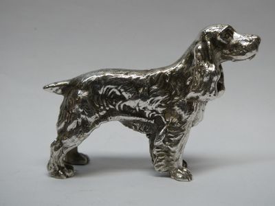 figurine de chien argentée sur fond blanc