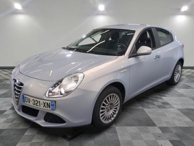 La voiture blanche est garée sur le sol à damier de la pièce.