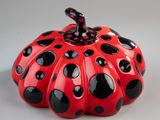 red and black ceramic pumpkin with black dots on it