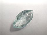 a close up of a green and white gemstone on a white surface