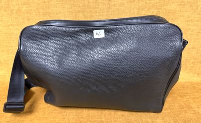 une trousse de toilette en cuir noir sur fond jaune
