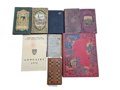 several old books sitting on top of each other on a white surface