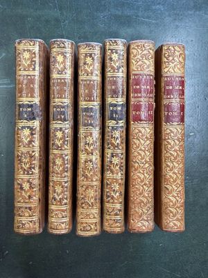 cinq vieux livres alignés sur une table