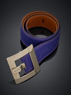 un gros plan sur une ceinture violette ornée d'une boucle argentée