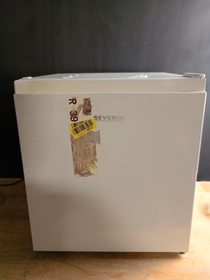 un réfrigérateur blanc posé sur une table en bois