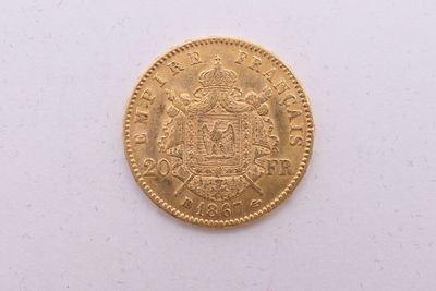gros plan d'une pièce d'or sur une surface blanche