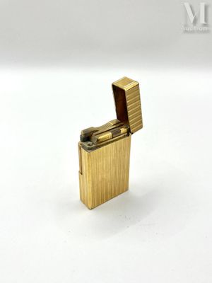 a gold lighter that is sitting on a white surface
