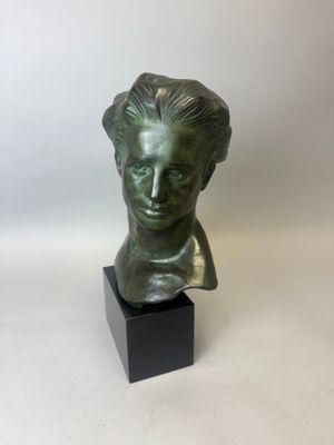 un buste en bronze représentant la tête d'une femme, posé sur un socle noir